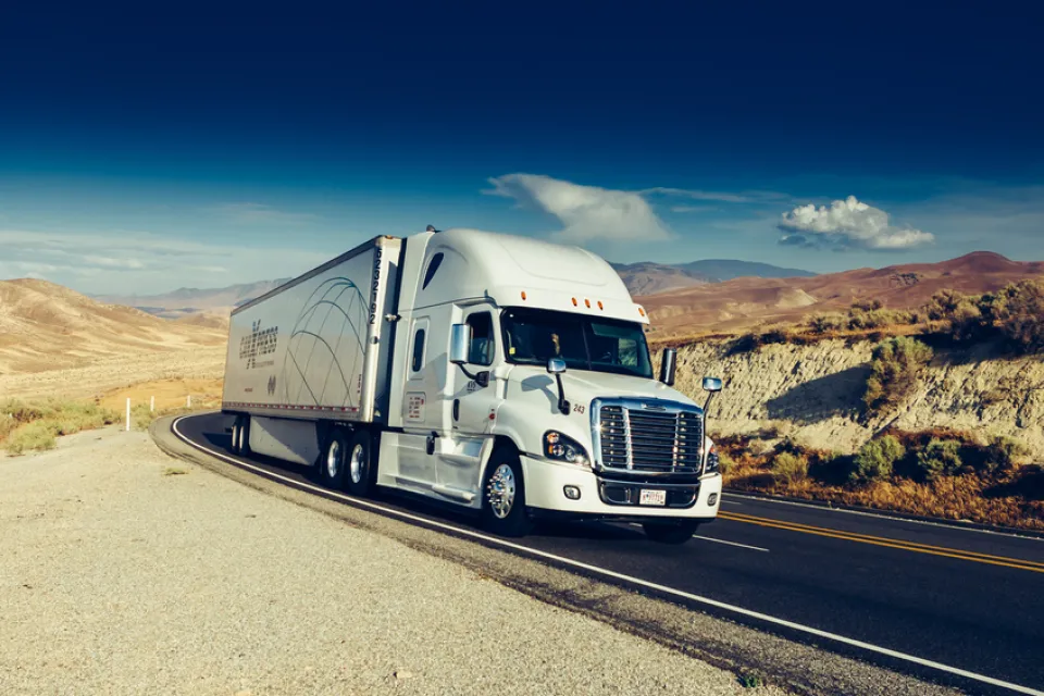 Diesel big rig truck on California road with mountains in background